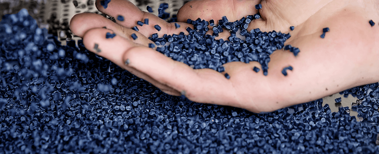 Palm holding blue UBQ material pellets.