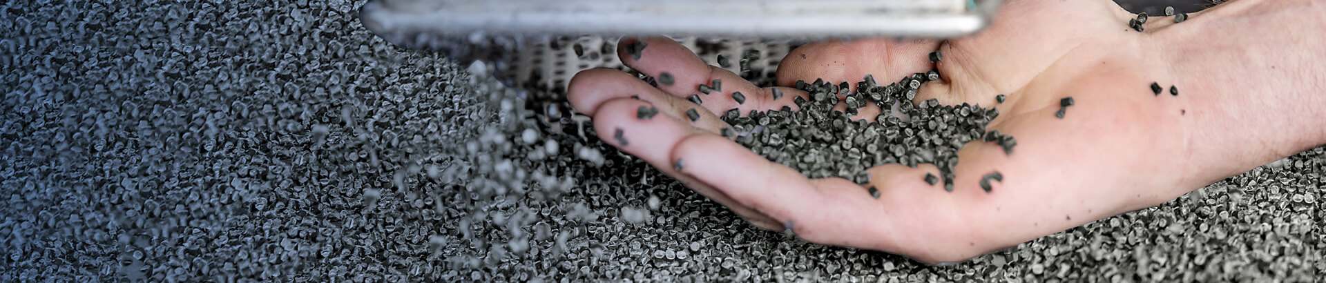 Hand holding UBQ material pellets.